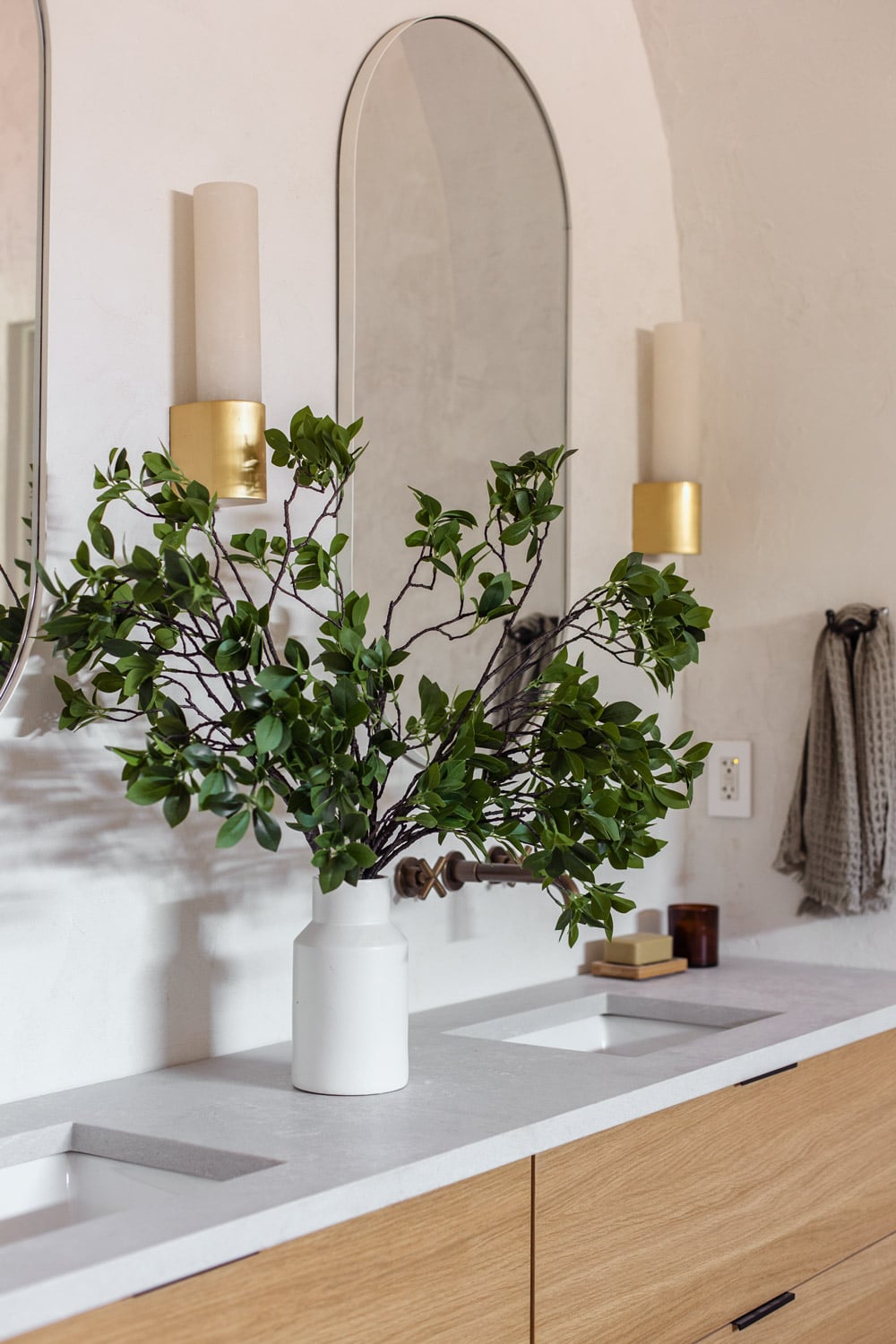 faux eucalyptus branches in vase in bathroom