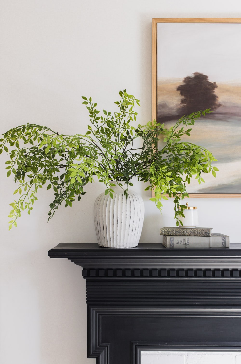 artificial nandia greenery in vase on fireplace
