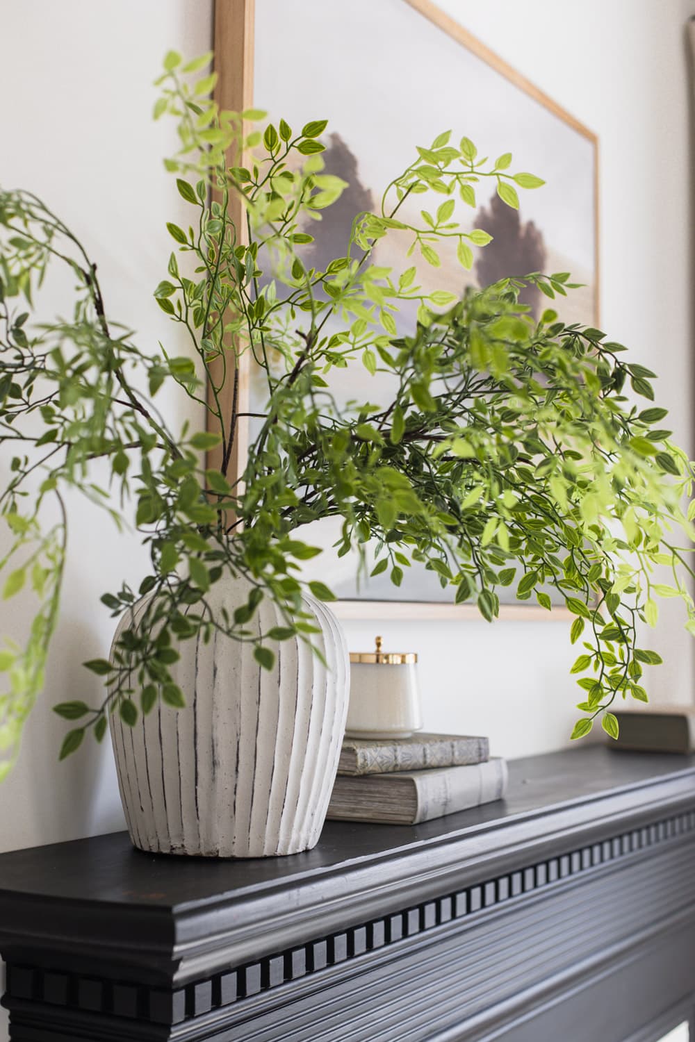 artificial nandia greenery in vase on fireplace