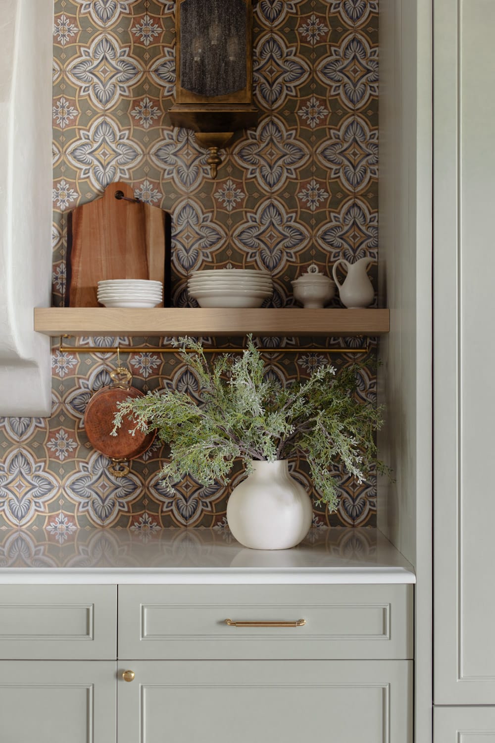 artificial seeded eucalyptus stems in vase on kitchen counter