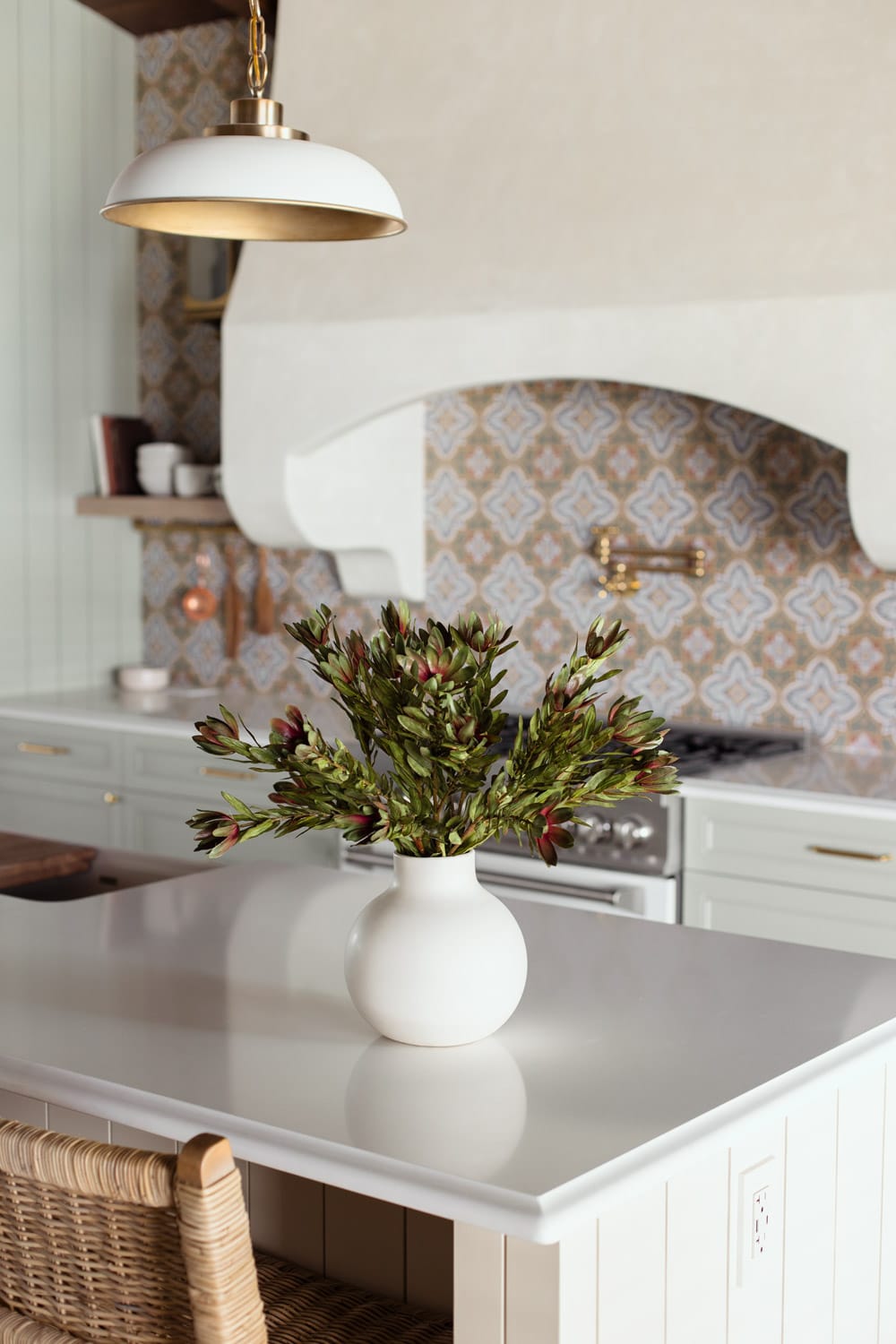 faux wild protega stems in vase on kitchen island