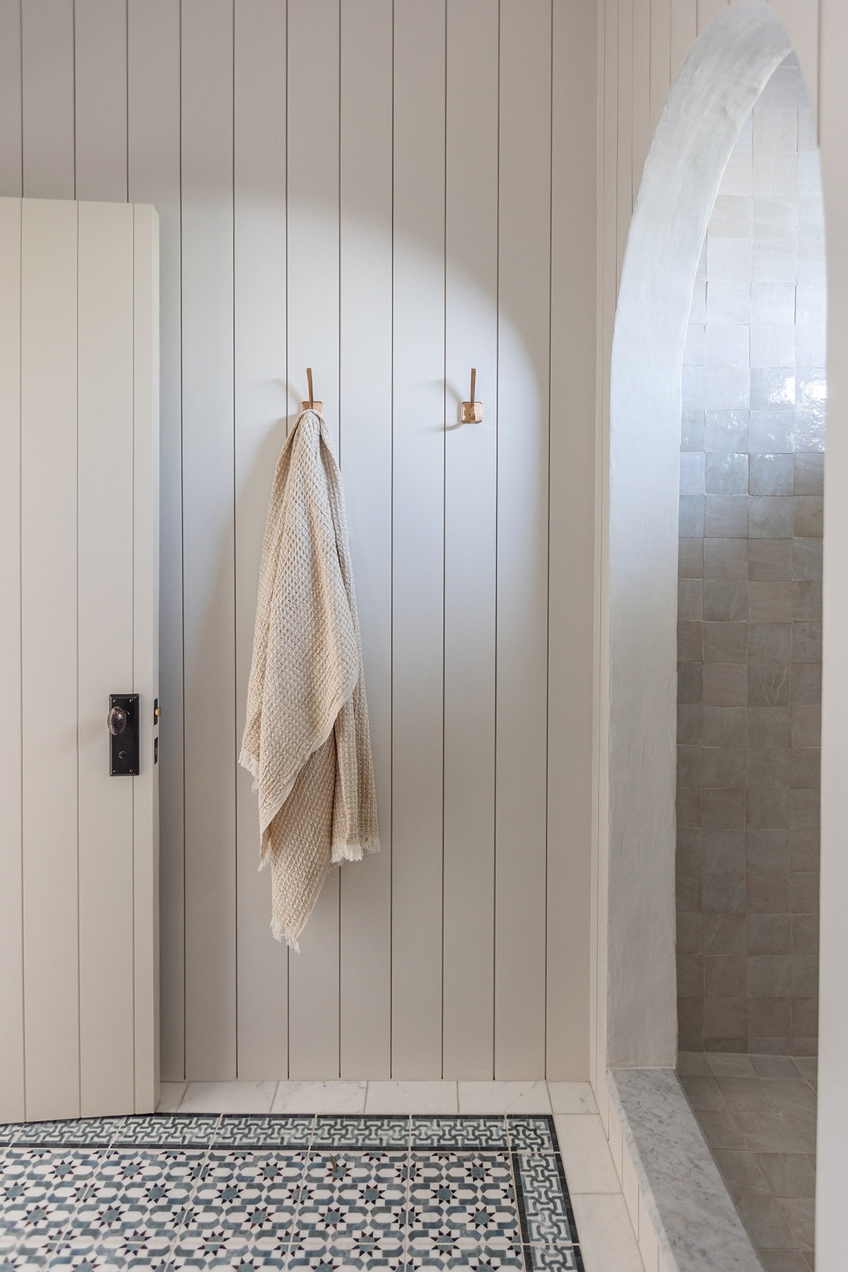 bathroom with sherwin williams egret white shiplap walls and arched shower opening