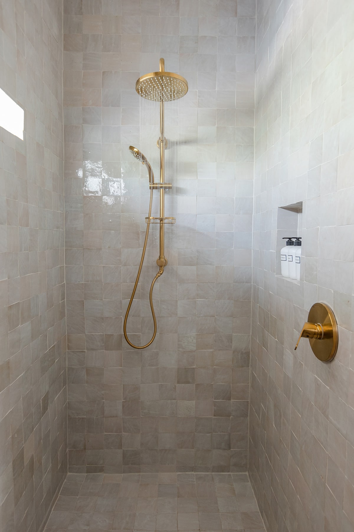 shower with natural white zellige tile and gold shower system