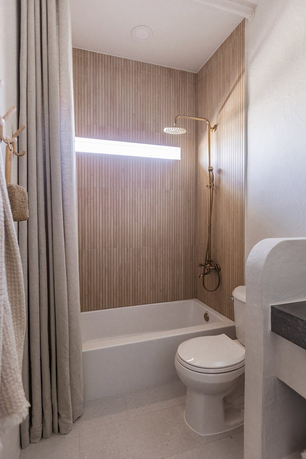 bathroom with wood look shower tile and microcement walls