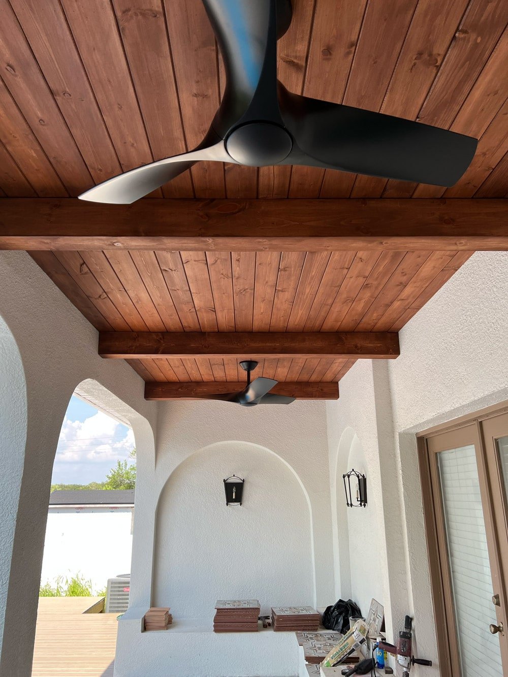 diy wood beam and plank porch ceiling with black fans