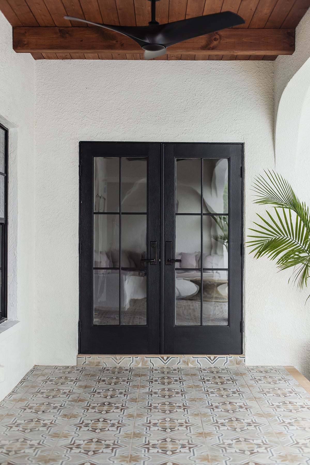 black french doors with diy window grilles on a tiled porch