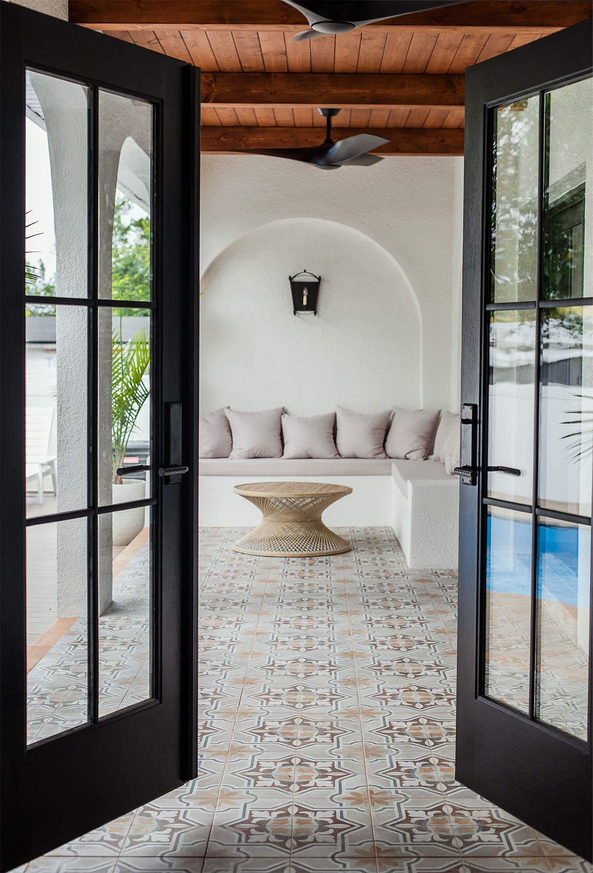 black french doors opening to spanish style patio