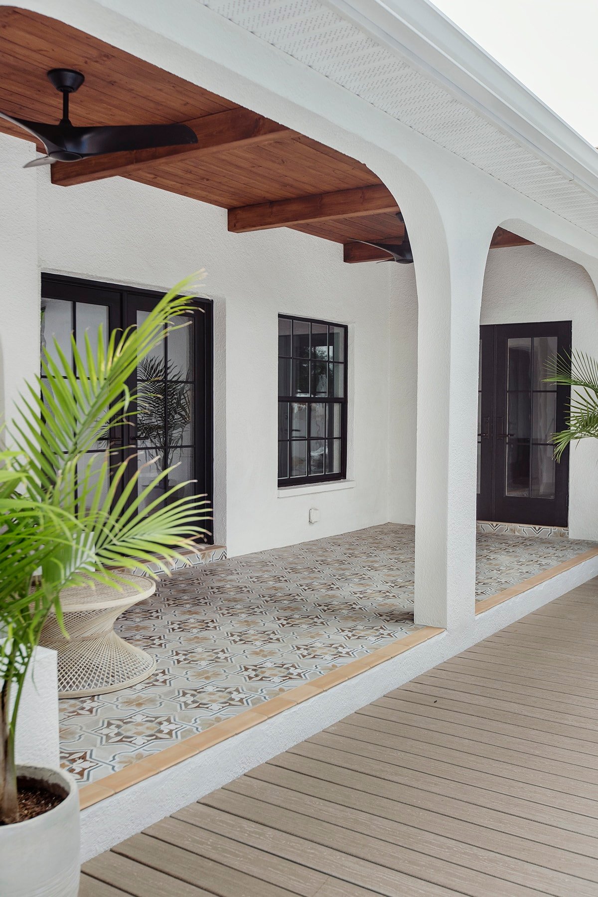 spanish style porch with wood beam ceiling, patterned tile and black french doors, diy arches