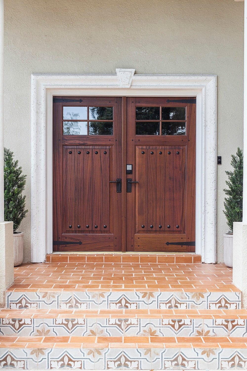 spanish style front door with rustic black metal hinge straps and clavos
