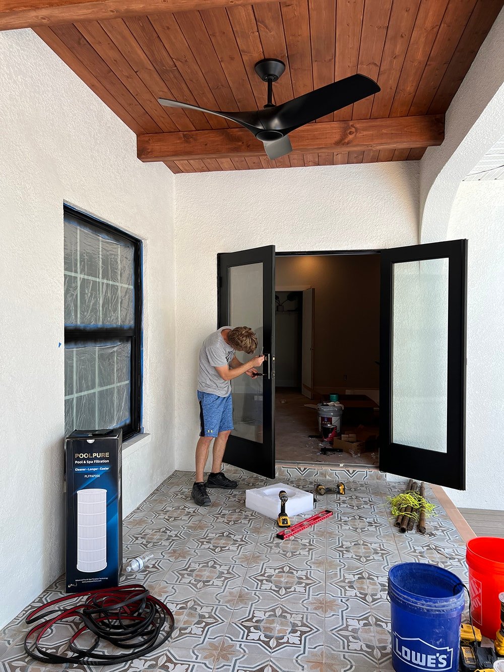 diy porch makeover with wood beams and black french doors