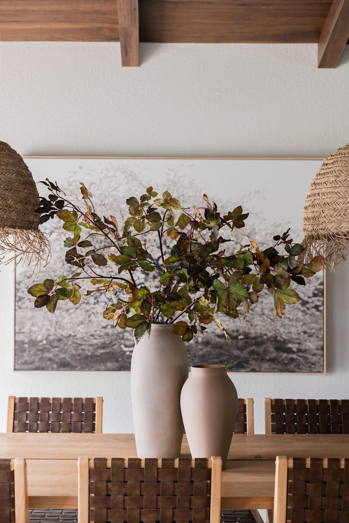 faux fall chestnut leaf branches in terracotta vase on dining table