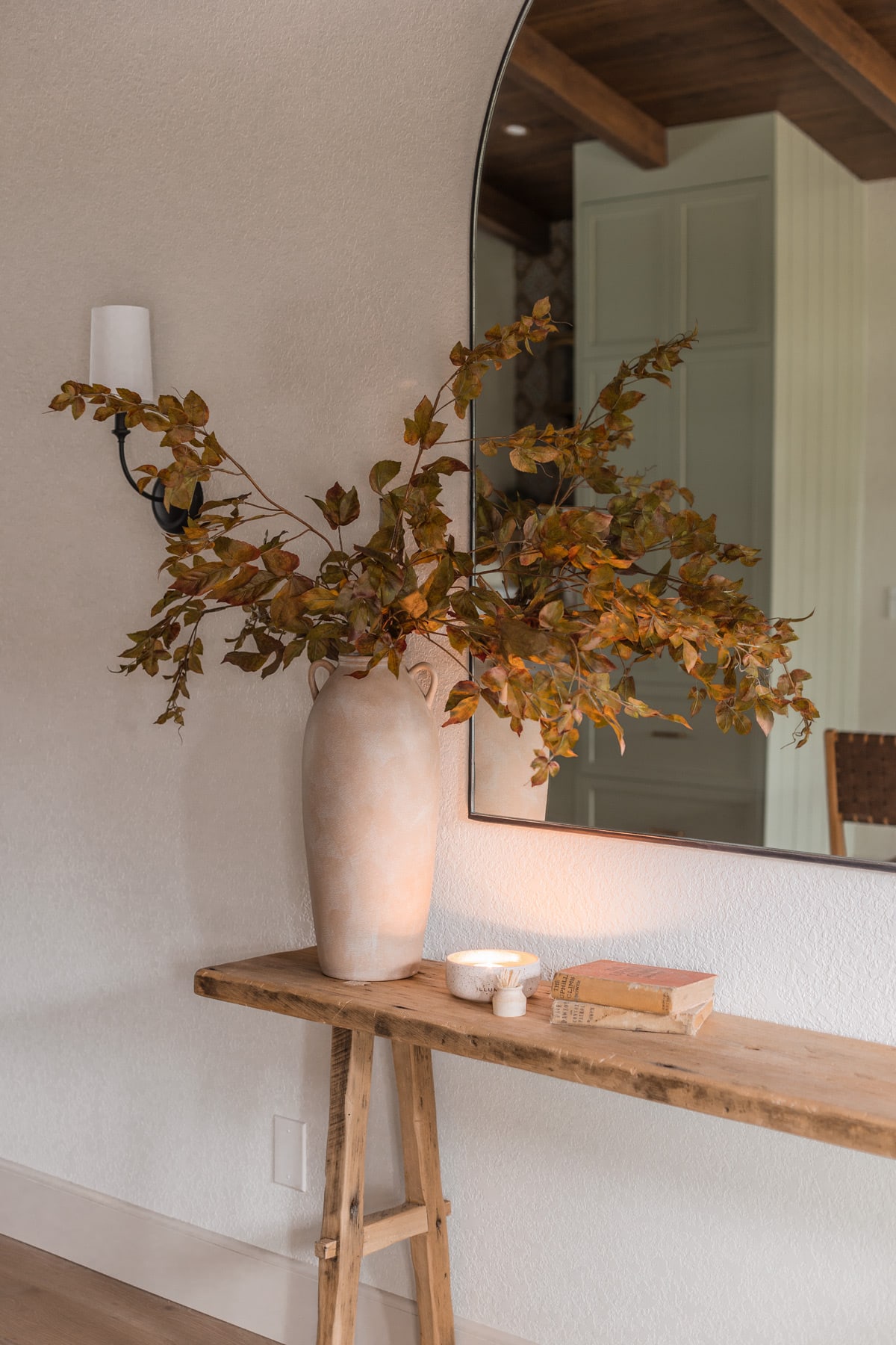 faux grape leaf fall branches in vase on console table