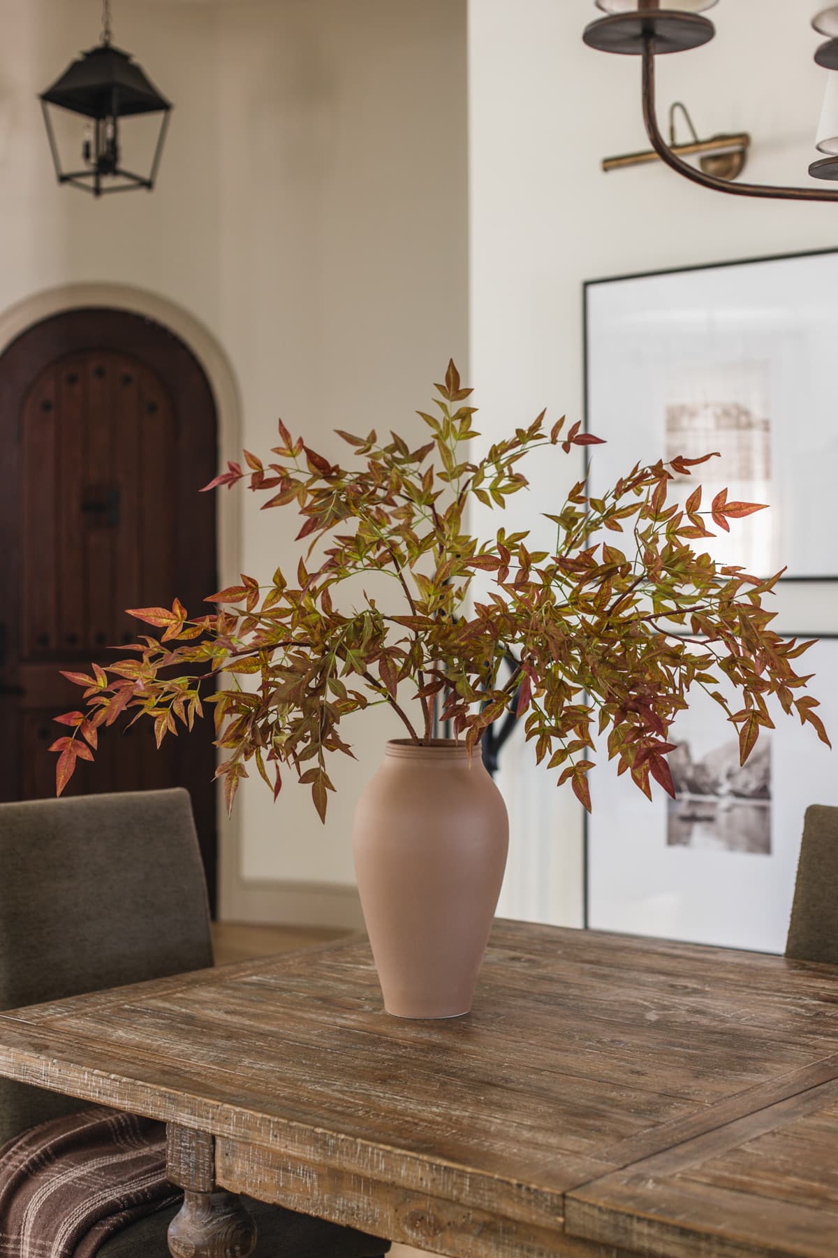 faux fall branches in vase on dining table