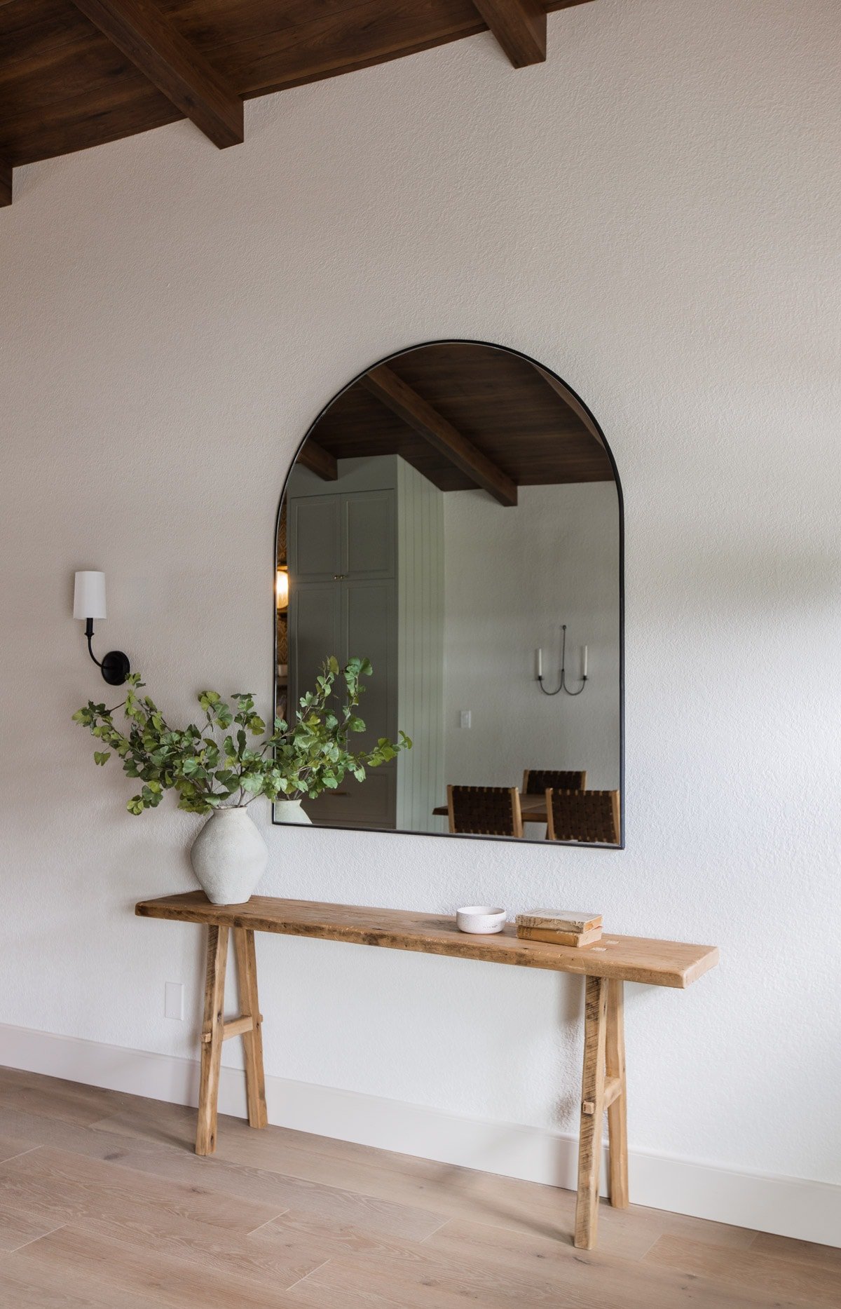 spanish style entrance with rustic wood table and arch mirror