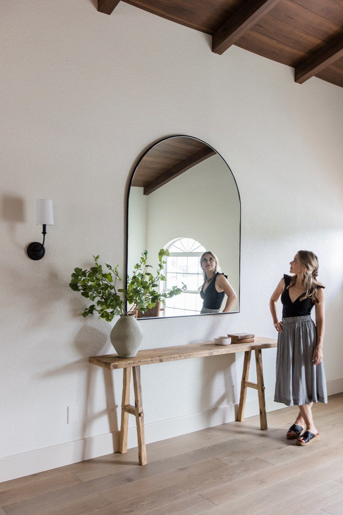 spanish style entrance with rustic wood table and arch mirror