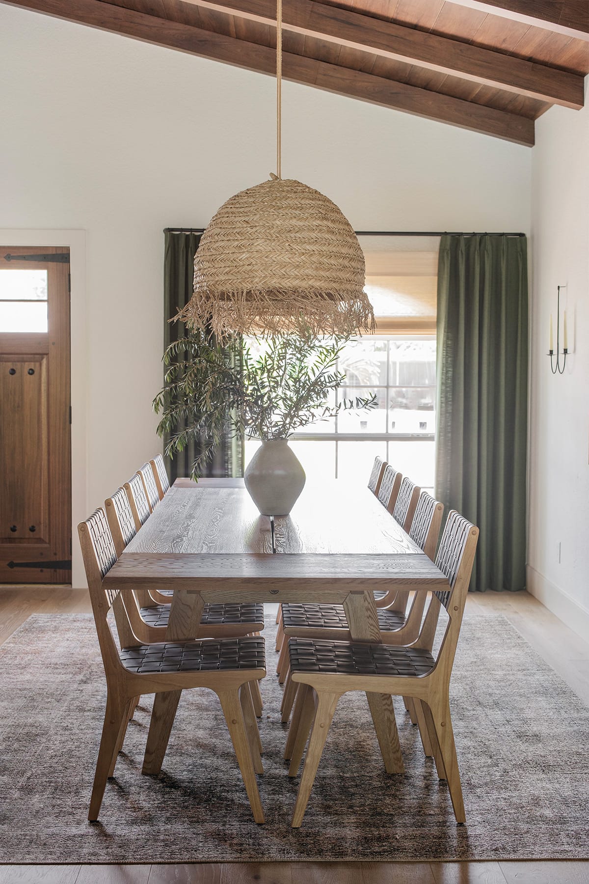 mediterranean style dining room with wood and leather chairs, seagrass pendant lights