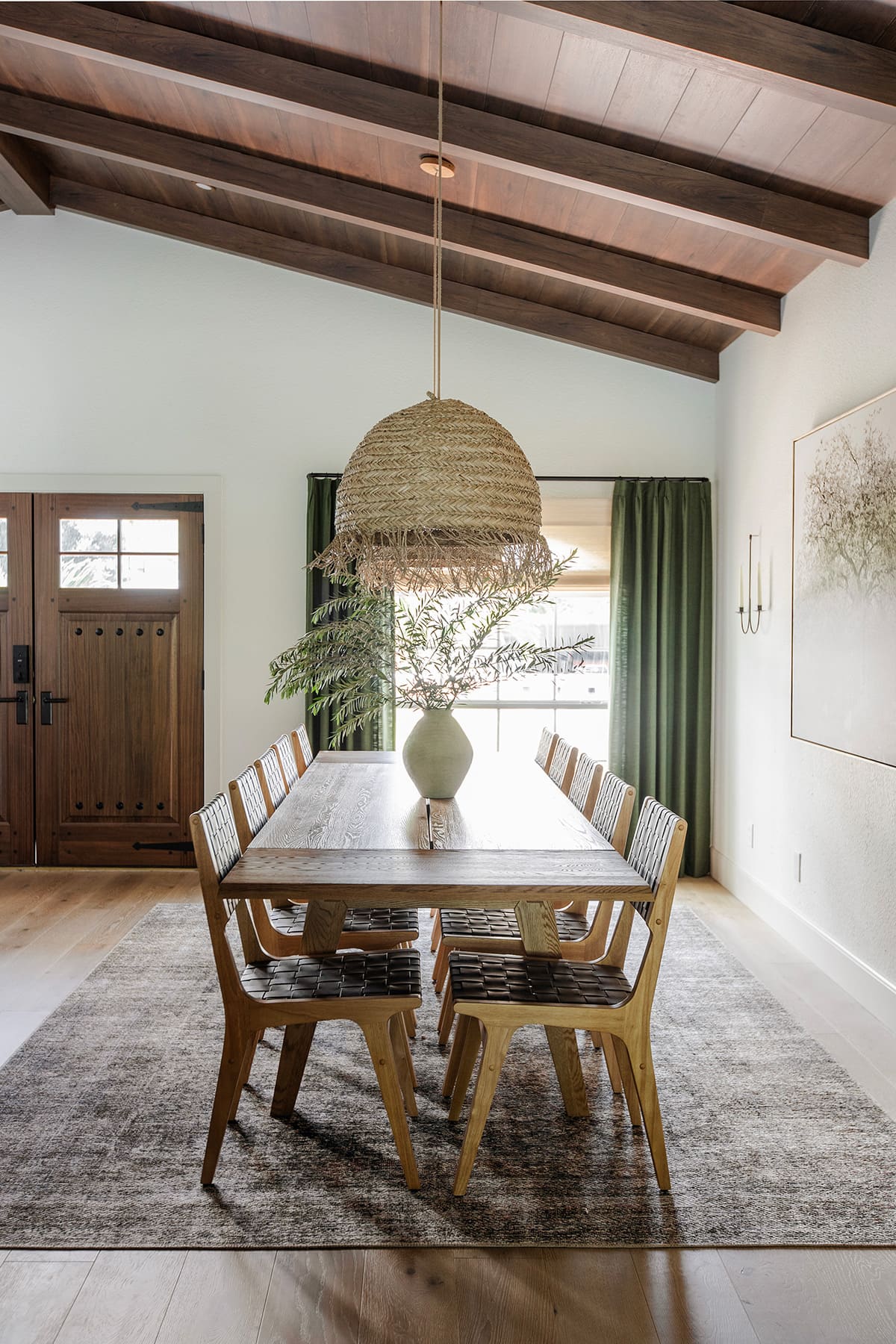 mediterranean style dining room with wood beam ceilings, large table, seagrass pendant lights