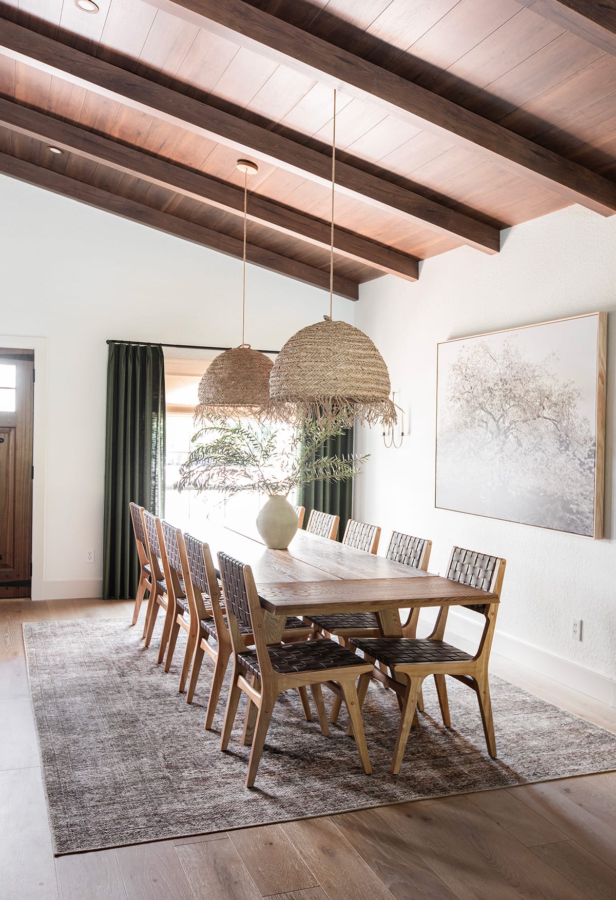 mediterranean style dining room with wood beam ceilings, large table, seagrass pendant lights