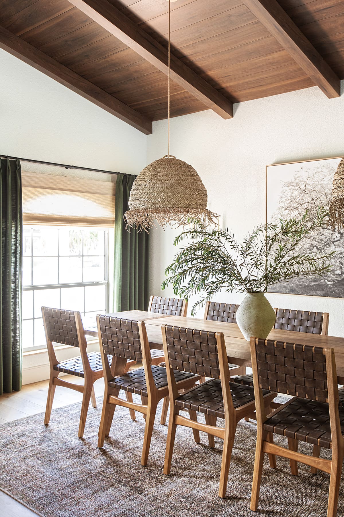 mediterranean style dining room with wood beam ceilings, large table, seagrass pendant lights