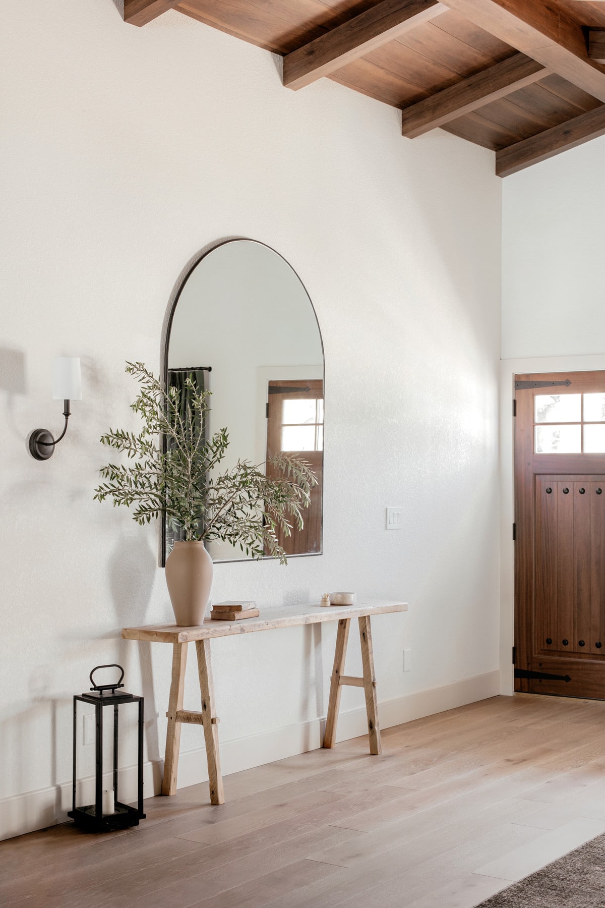 mediterranean style foyer with wood ceilings, console table, arch mirror