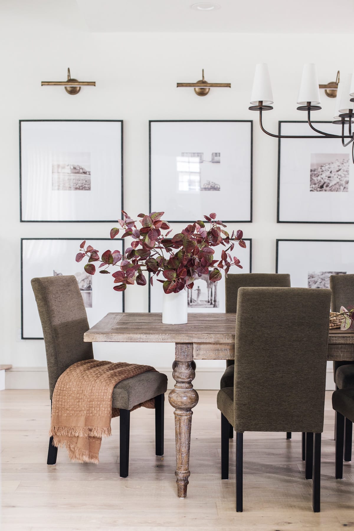 dining room with a gallery art wall and picture lights