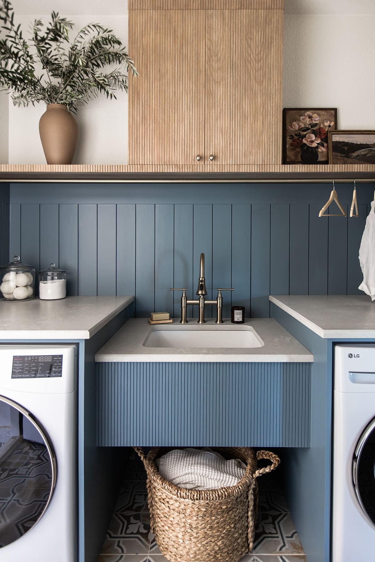 laundry room with sherwin williams blustery sky walls, quartz countertops, pole wrap shelf and hanging rod