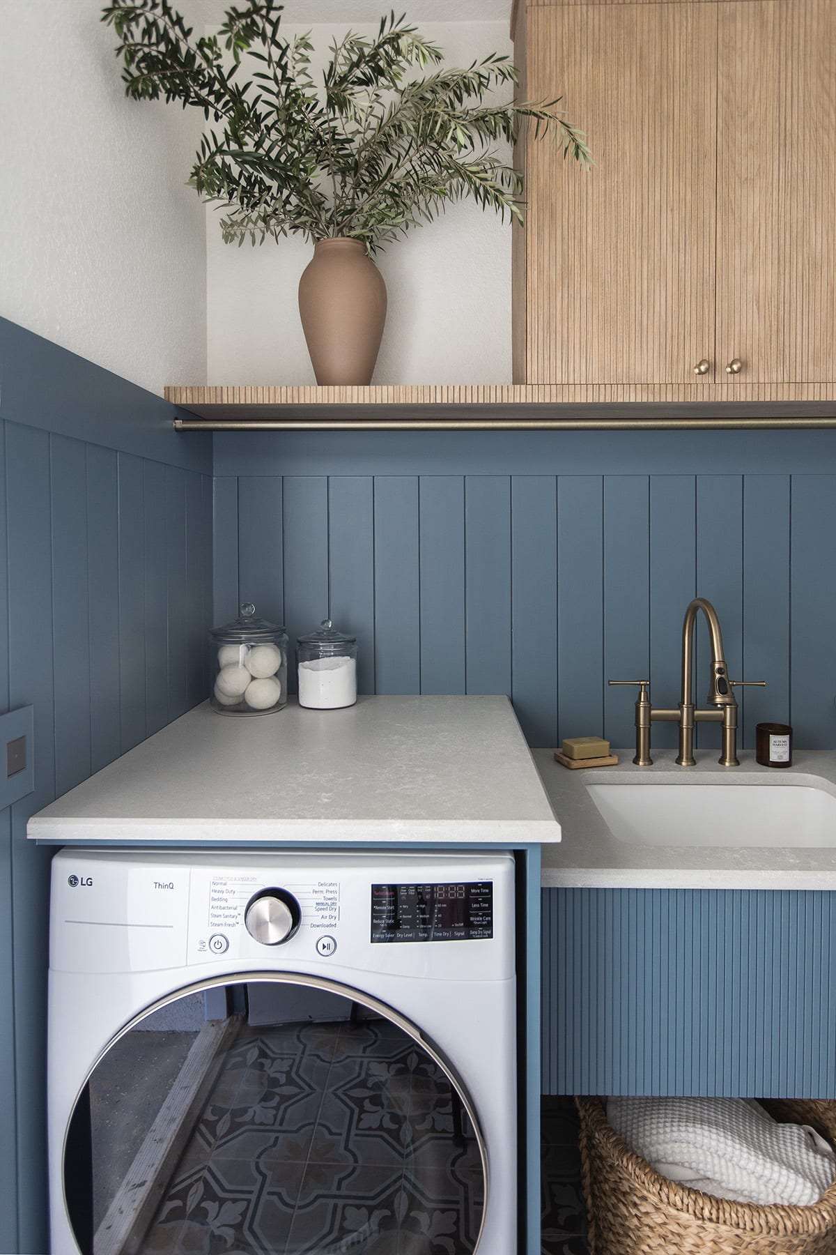 laundry room with sherwin williams blustery sky walls, quartz countertops, pole wrap shelf and hanging rod