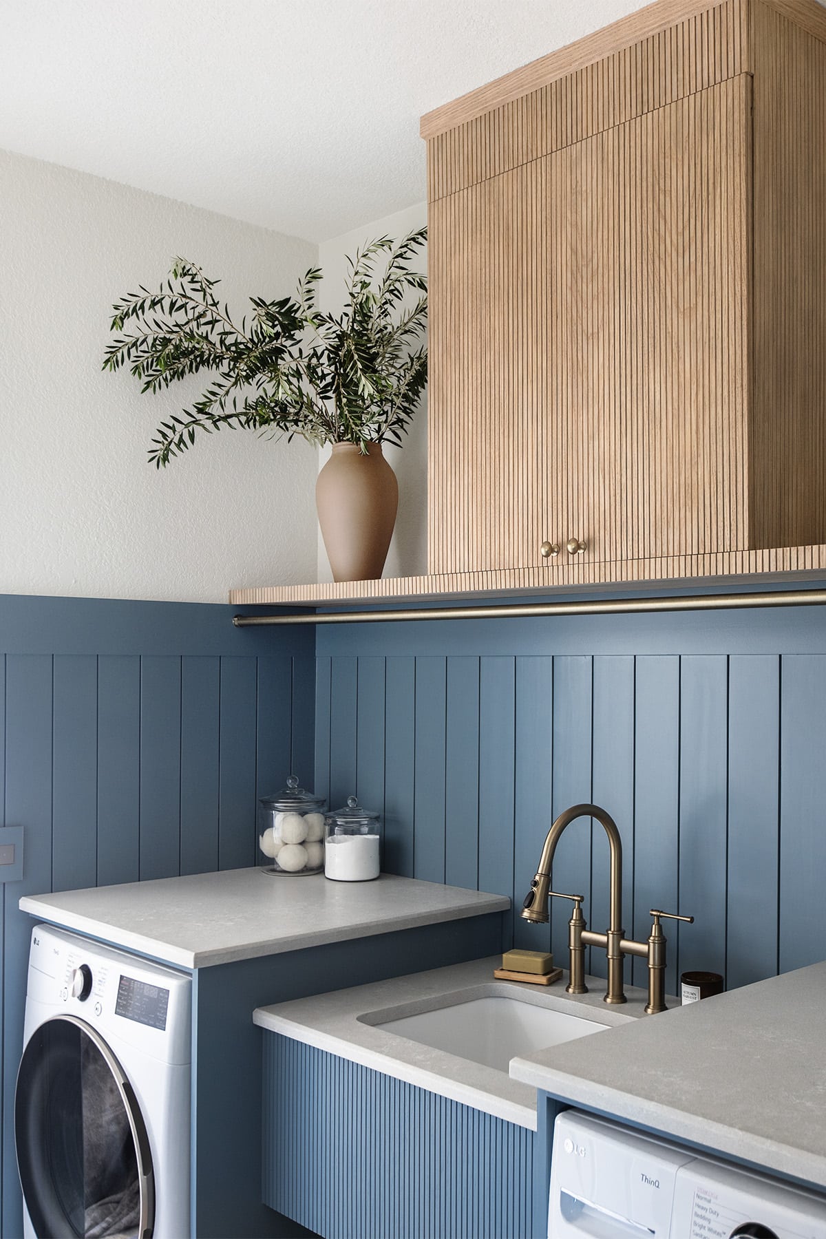 laundry room with sherwin williams blustery sky walls, quartz countertops, pole wrap shelf and hanging rod