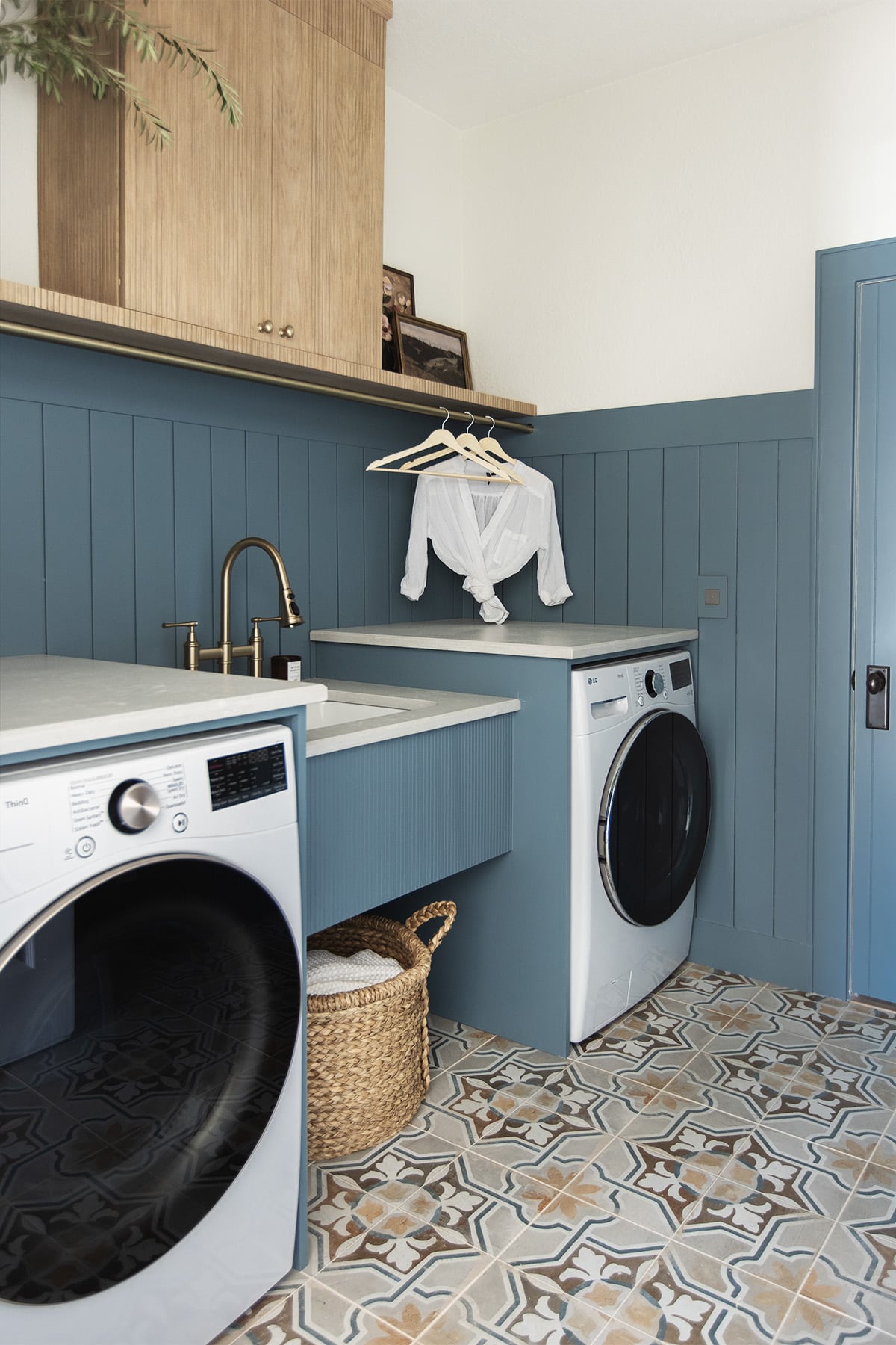 laundry room with sherwin williams blustery sky walls, quartz countertops, pole wrap shelf and hanging rod