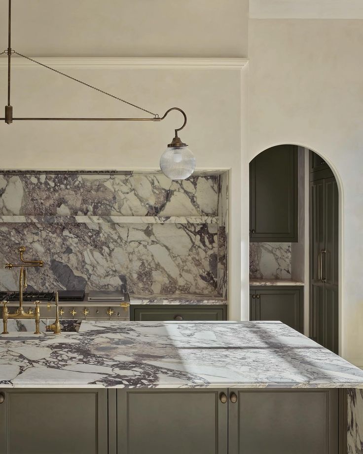 lime wash kitchen wall and range hood with marble backsplash