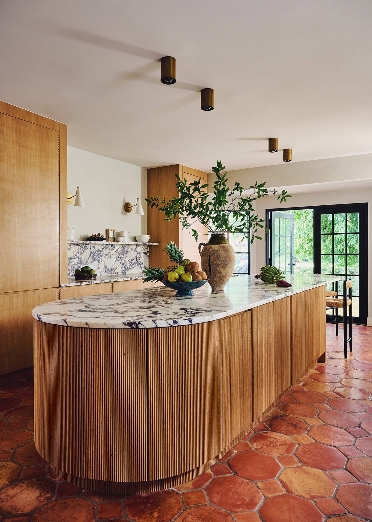 rounded fluted island with wood cabinets