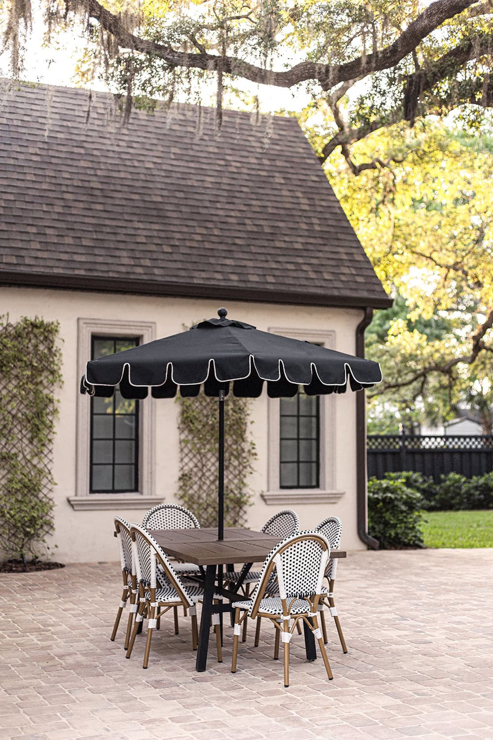 paver patio with walmart dining table, bistro chairs and black scalloped umbrella