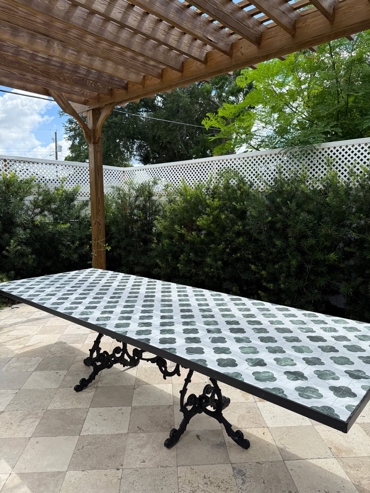 tiled outdoor dining table under a pergola