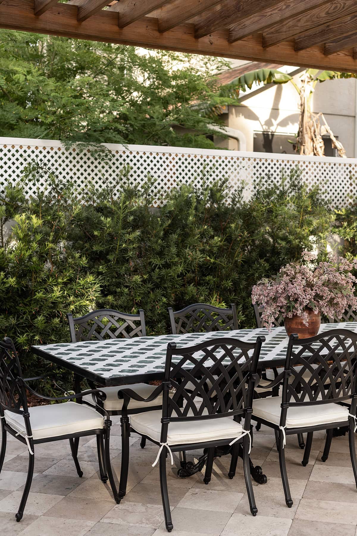 european backyard outdoor tile dining table under a wood pergola