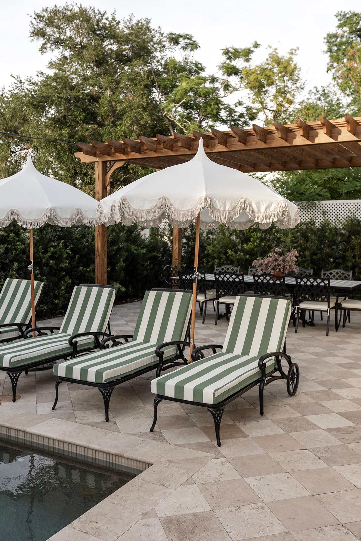 european backyard chaise lounges umbrella checkered travertine patio