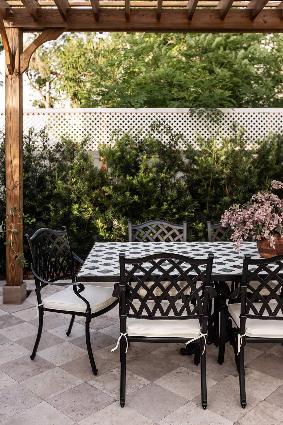 european backyard outdoor tile dining table under a wood pergola